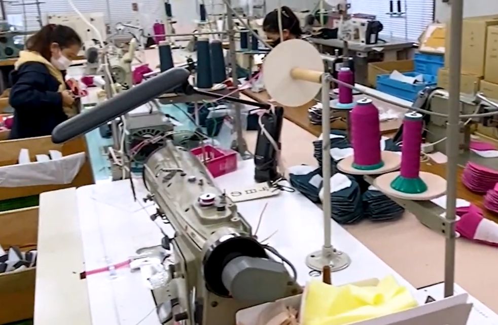 縫製工場の作業場を見学する様子